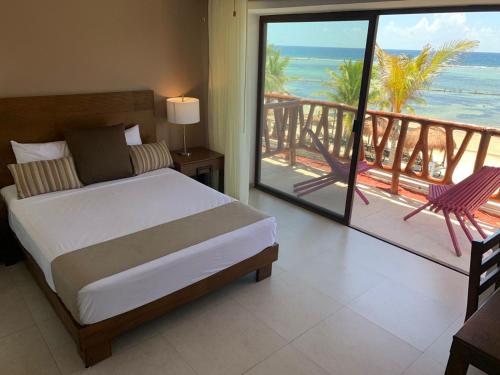 a bedroom with a bed and a view of the beach at Quinto Sole in Mahahual