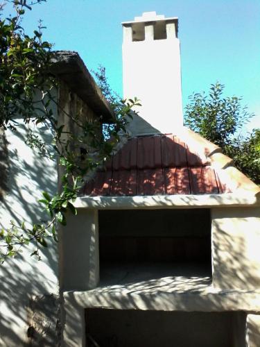 a white building with a brown roof and some trees at House Marija in Lastovo