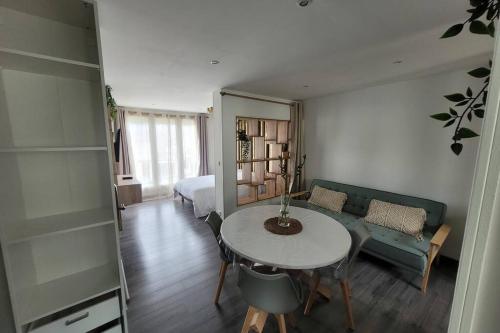 Habitación con mesa, sofá y dormitorio. en Le Nid d'Opale, en Berck-sur-Mer