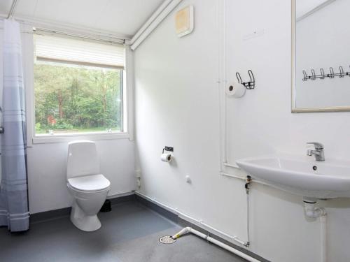 baño con lavabo y aseo y ventana en Holiday home Herning III en Herning