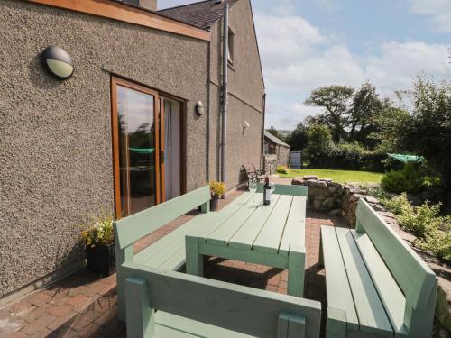 a wooden bench sitting on a deck next to a building at Caer Moel in Llanwnda