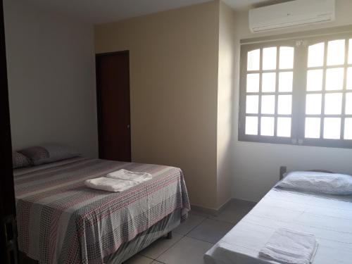 a bedroom with two beds and a window at Casa na Praia dos Carneiros - Tamandaré in Tamandaré