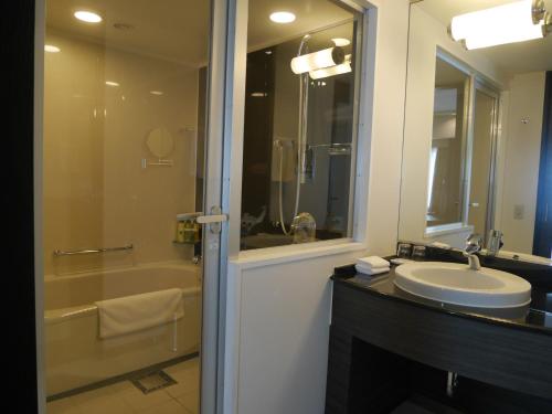 a bathroom with a sink and a tub and a shower at ANA Crowne Plaza Fukuoka by IHG in Fukuoka