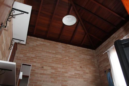 un plafond avec une lumière au-dessus d'un mur de briques dans l'établissement RECANTO HARMONIA, à Conceição da Ibitipoca