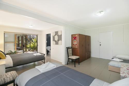 a bedroom with two beds and a chair at HideAway - Tweed Coast Holidays in Cabarita Beach