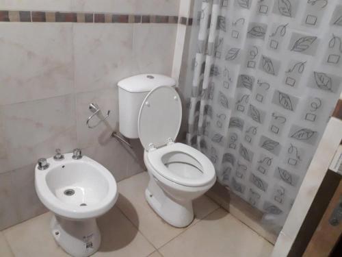 une salle de bain avec toilettes et rideau de douche dans l'établissement León Apart -un dormitorio-, à Corrientes