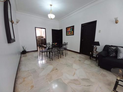 a living room with a couch and a table and chairs at Del Sol Suites - Apartamento Familiar in Guayaquil