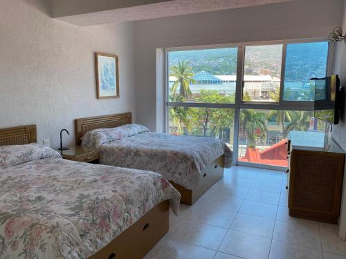 A bed or beds in a room at Comfortable Beachfront apartment in Acapulco