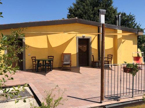 une petite maison jaune avec une table et des chaises dans l'établissement Timeless Holiday Home in Apecchio with Garden, à Apecchio