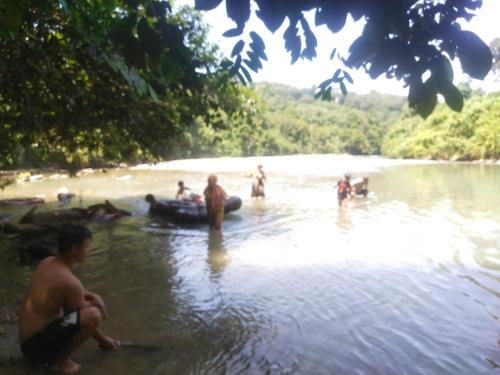 a group of people in the water on a river at Mountain View Cottages & Villa Tangkahan in Tangkahan