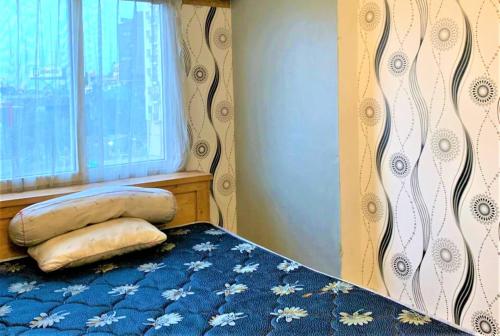 a bed with two pillows on it in front of a window at Apartemen Mutiara Bekasi by Veeroom in Bekasi