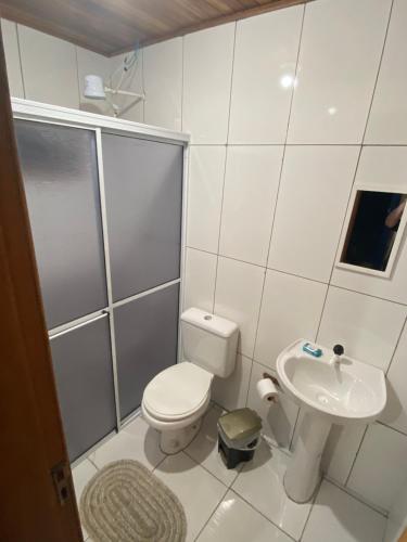 ein weißes Bad mit einem WC und einem Waschbecken in der Unterkunft CASA DE CAMPO FAZENDA DAS PELOTAS in Bom Jardim da Serra
