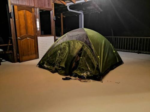 a green tent sitting in a room next to a door at Kairos Villa in Seremban
