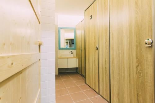 a hallway with a bathroom with a sink and a mirror at 阿信輕旅 in Tainan