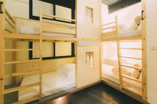 a room with four bunk beds in it at 阿信輕旅 in Tainan