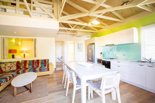 a kitchen with a table and chairs and a couch at BEACHBREAK - 100m to beach - sleeps 6 in Point Lookout