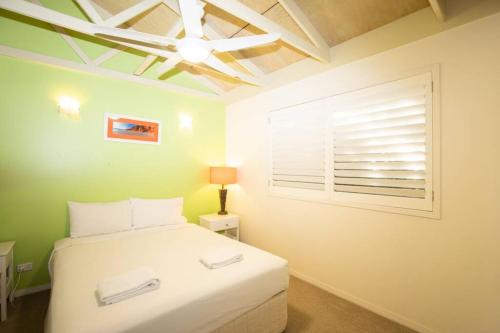 um quarto com uma cama branca e uma janela em BEACHBREAK - 100m to beach - sleeps 6 em Point Lookout