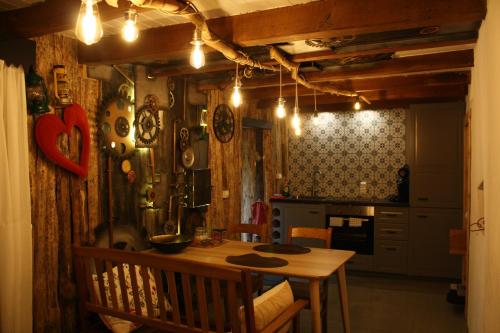a kitchen with a wooden table and a dining room at La petite romantique in Martelange