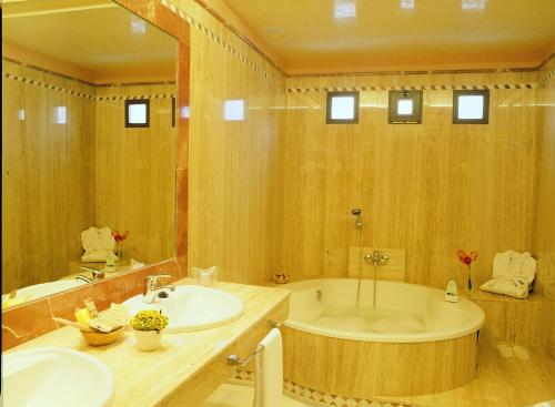 a large bathroom with a tub and a sink at Hotel Abades Guadix in Guadix