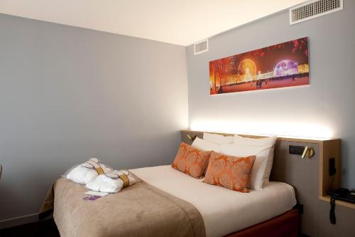 a bedroom with a bed with a painting on the wall at Mercure Lyon Charbonnières in Charbonnières-les-Bains