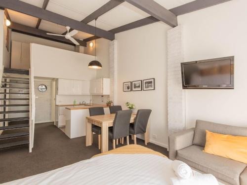a living room with a table and a couch and a kitchen at 23 at the Gables in Jindabyne