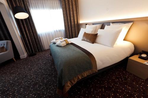 a hotel room with a bed and a window at Mercure Lyon Charbonnières in Charbonnières-les-Bains