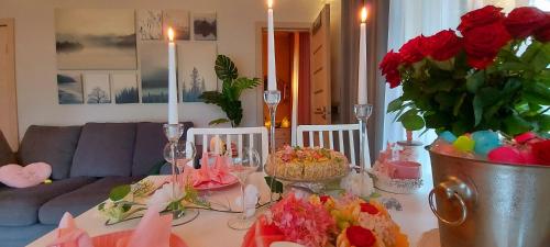 a living room with a table with candles and flowers at Brīvdienu māja ar Saunu in Saulkrasti