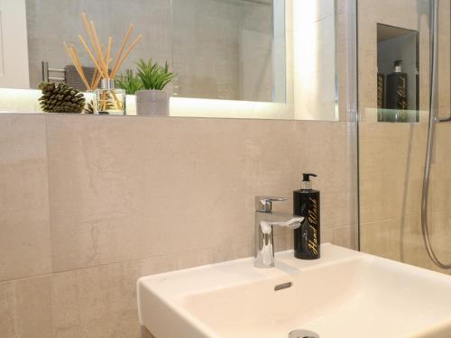 a bathroom with a sink and a mirror at The Observatory Annexe in Dorking