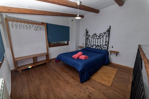 a bedroom with a blue bed with red pillows on it at Casa El Volaero in Hornos