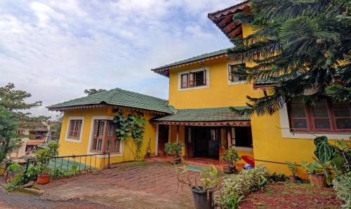 a yellow house with a green roof at Itsy By Treebo - Vailankanni Natures Inn in Panaji