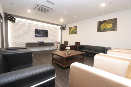 a living room with black leather furniture and a table at Villea Rompin Resort & Golf in Kuala Rompin