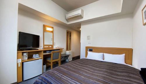 Postel nebo postele na pokoji v ubytování Hotel Route-Inn Tsubamesanjo Ekimae