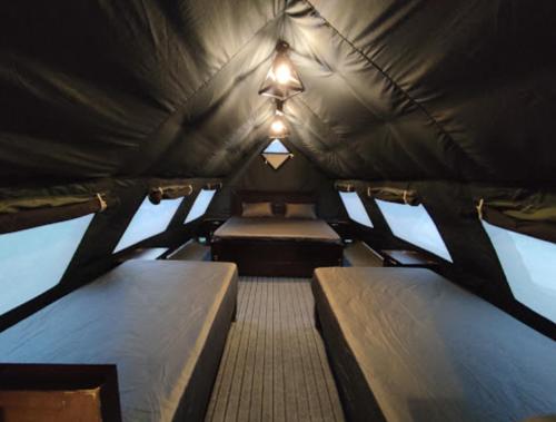 Kumrat Glamping Resorts في Tāl: غرفة صغيرة بسريرين في خيمة
