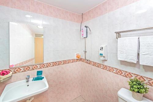 a bathroom with a sink and a toilet and a mirror at Hotel 81 Lucky in Singapore