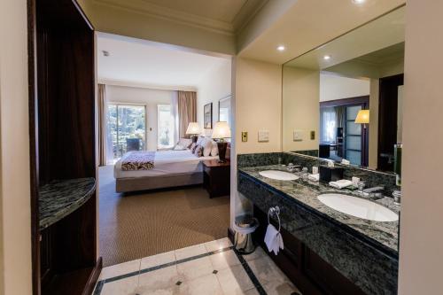 a hotel room with two sinks and a bed at Joondalup Resort in Perth