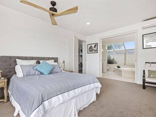 a white bedroom with a bed and a bathroom at Blue Horizon Mt Eliza in Mount Eliza
