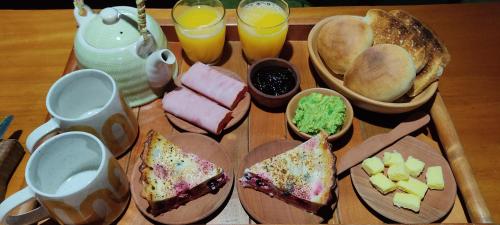 ein Tablett mit Essen, Sandwiches, Brot und Getränken in der Unterkunft cabaña entre coihues y arrayanes in Villarrica