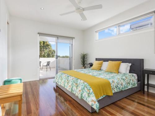 a bedroom with a bed with a yellow blanket at Trinity Beach House in Rosebud
