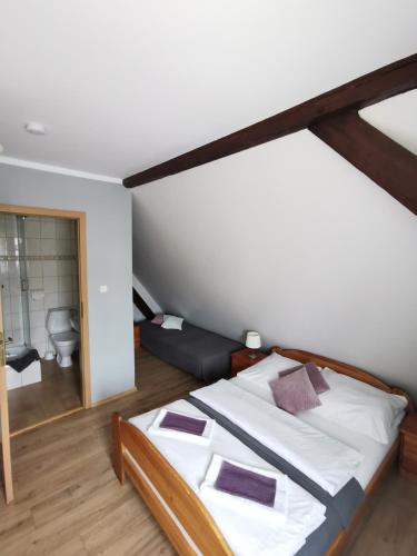 a large bed in a room with a bathroom at Zielony Dom in Bolesławiec