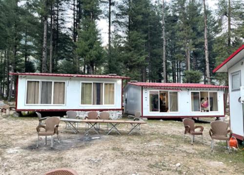 - deux petites maisons avec des chaises et une table dans l'établissement Panjkura Hotel And Resorts, à Tāl