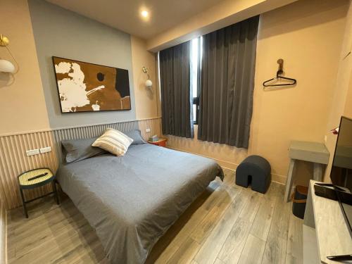 Un dormitorio pequeño con una cama y una ventana. en 田町包棟旅宿TAMACHI Inn, en Tainan