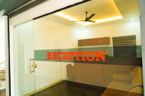 a reflection of a reception sign in a window at THEKKUMPURAM RESIDENCY in Kondotti