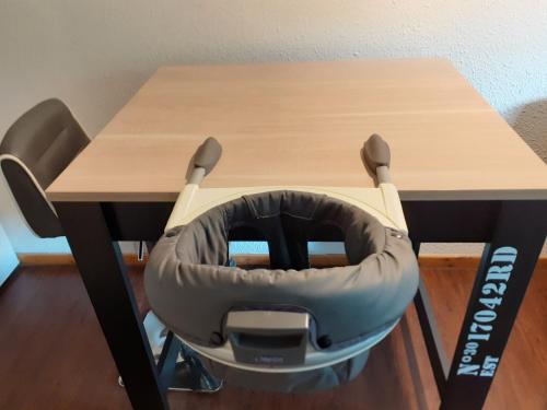 a chair sitting under a desk with a table at Appartement dans residence de tourisme in Besse-et-Saint-Anastaise