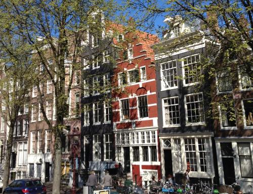 a tall building with white windows on a city street at Sonnenberg Canal View in Amsterdam