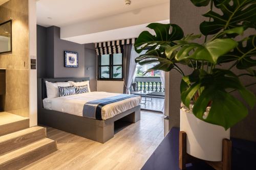 新加坡的住宿－Heritage Collection on Boat Quay - Quayside Wing - A Digital Hotel，一间卧室配有一张床和盆栽植物