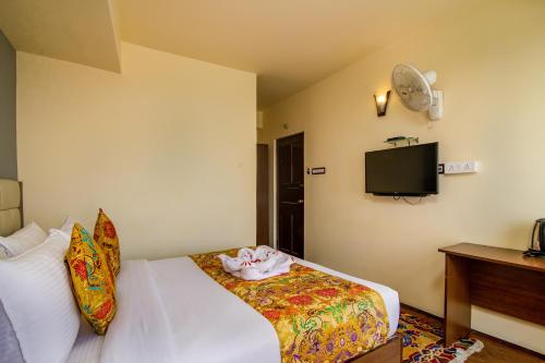 a hotel room with a bed and a tv at Muscatel Grand Silkroute - 300 Mts from MG Marg in Gangtok