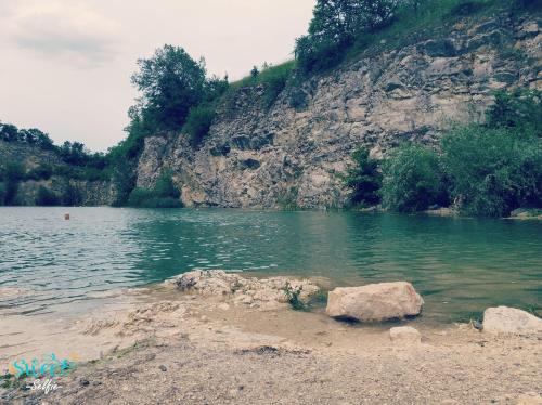 a body of water with a rock in front of a mountain at Ubytování U Špačků Pálava in Novosedly