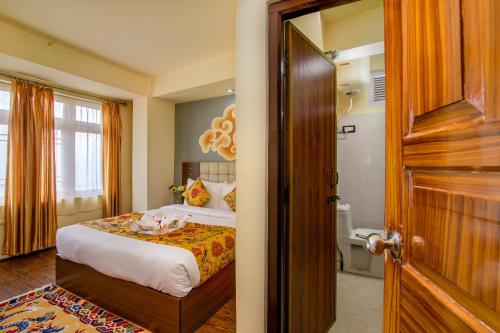 a bedroom with a bed with a dog laying on it at Muscatel Grand Silkroute - 300 Mts from MG Marg in Gangtok