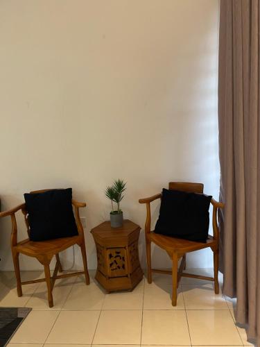 two chairs and a table with a potted plant on it at HnR HOMESTAY PORT DICKSON in Port Dickson