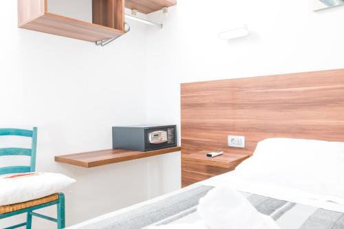 a bedroom with a bed and a tv on a wall at Stella Mare Eco Boutique House in Zavala